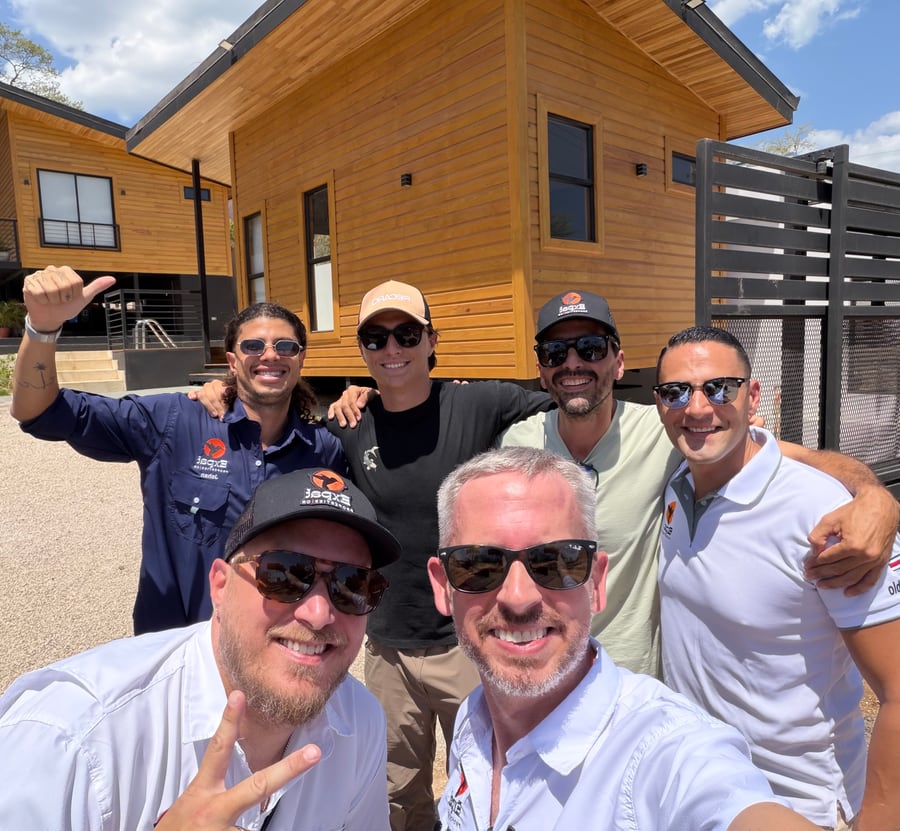 Group selfie with the build team in front of a newly finished timber house