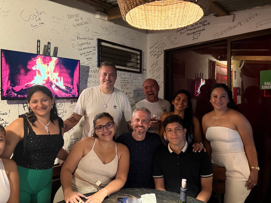 A big table of friends at a local bar with signatures covering the walls