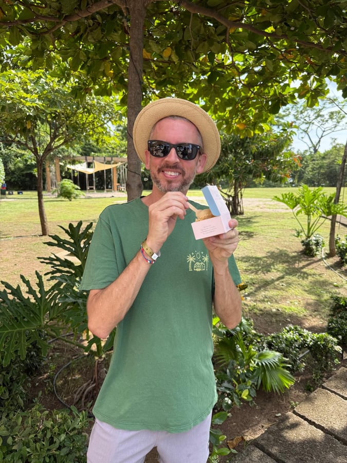 Standing on a green lawn under big shade trees in a panama hat